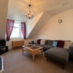 Shared living room with sofa, satellite TV and dining area in Lamond Place HMO